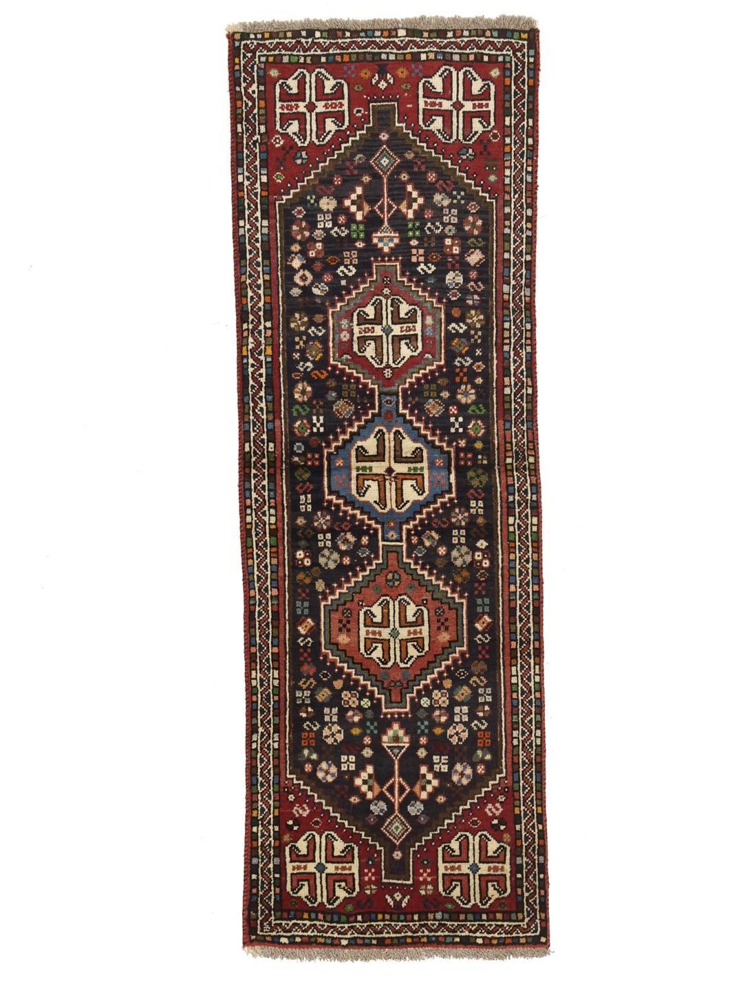 Hand-knotted Shiraz runner with a dark field and geometric motifs in red, blue, and white.
