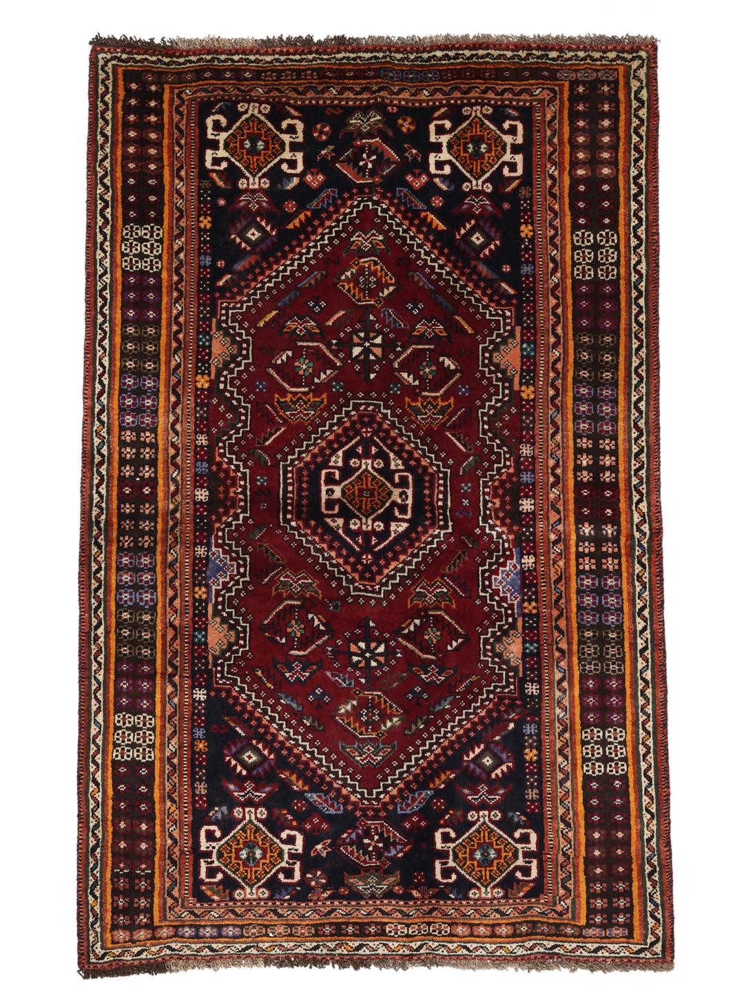 A hand-knotted Shiraz rug from the Middle East featuring a dark-red field and geometric patterns