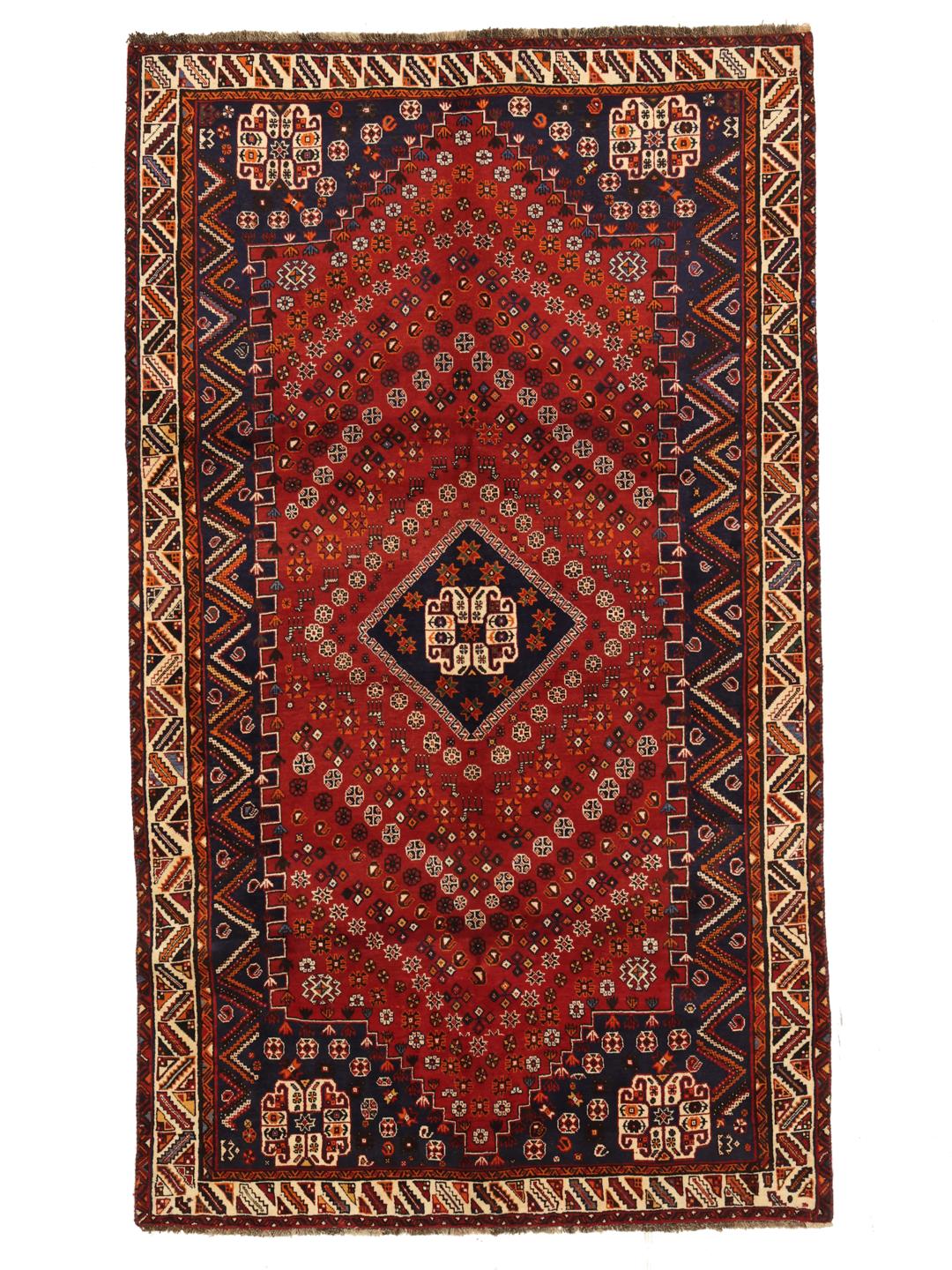 A hand-knotted Ghashghai rug from the Middle East featuring a red and dark-blue colour palette.