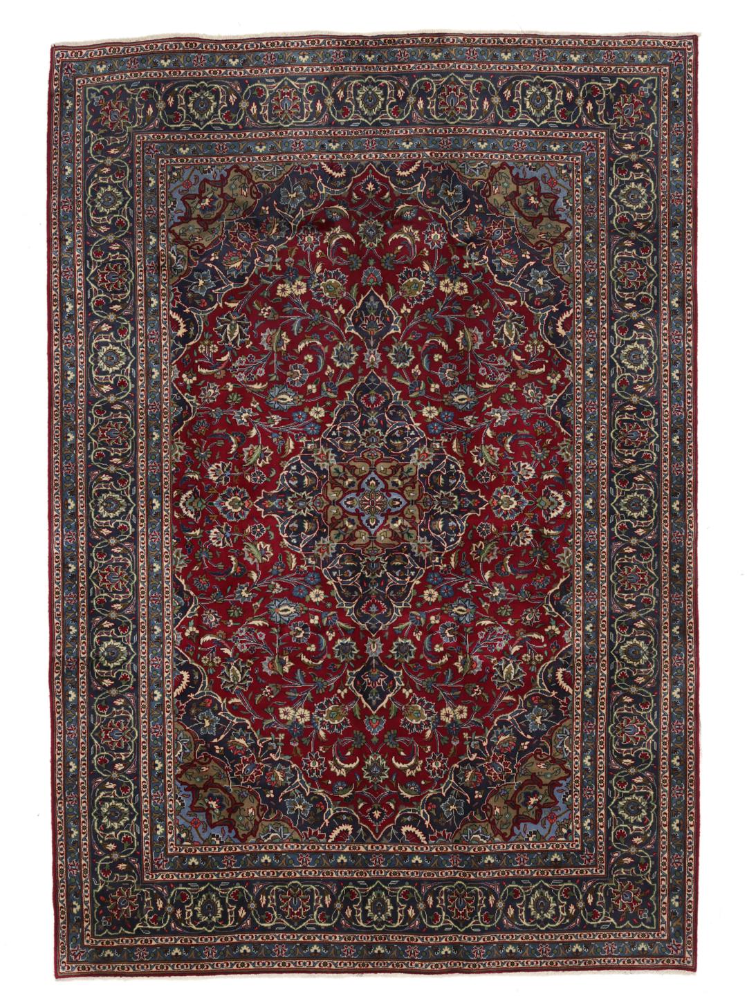 A hand-knotted Mashad rug from the Middle East with a deep red field and ornate patterns.