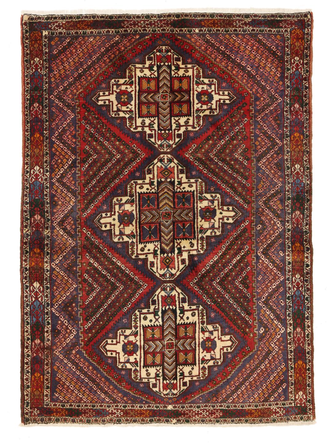 A hand-knotted Shahrbabak rug from the Middle East in deep red and blue tones.