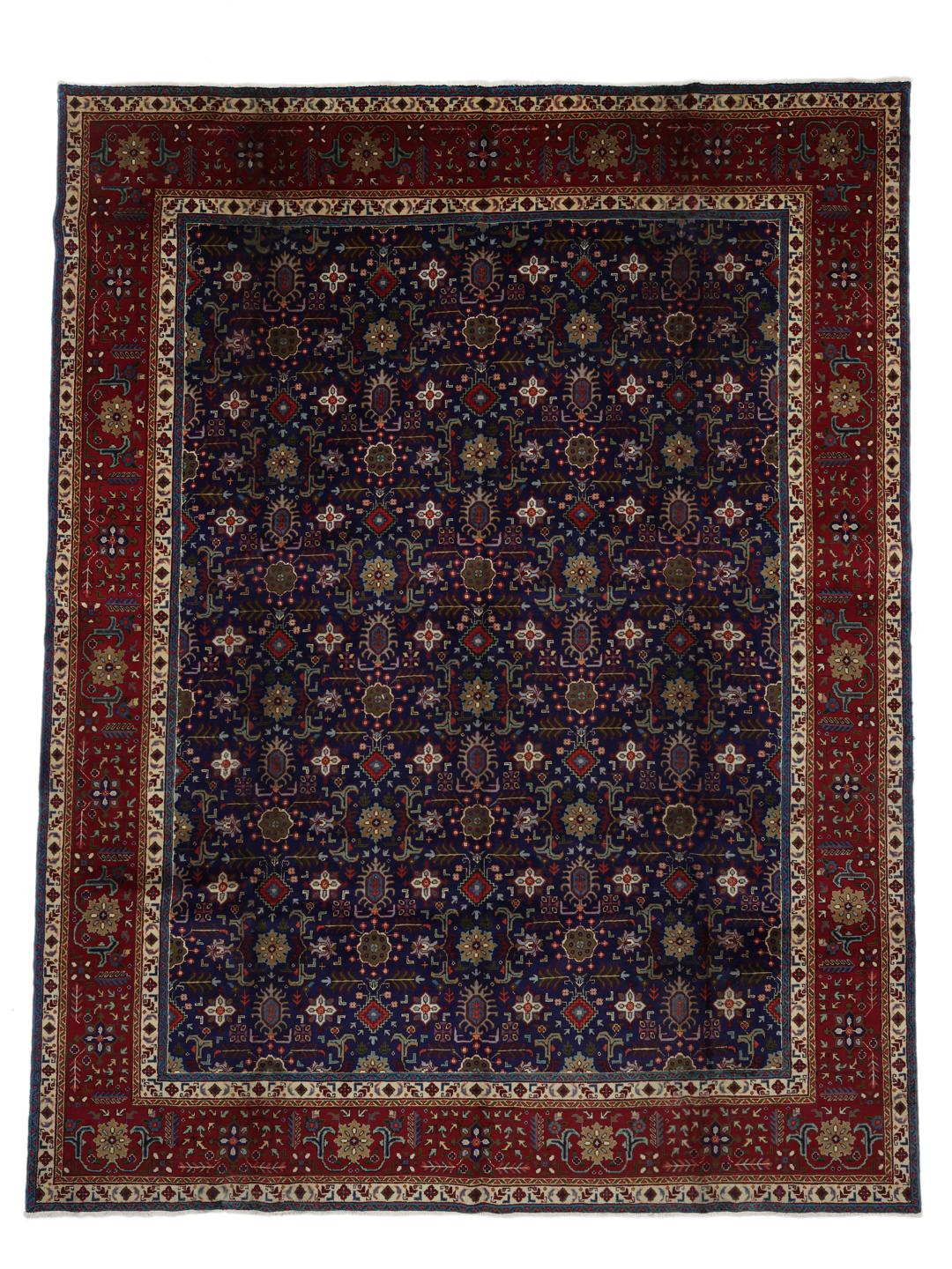 A large rectangular Tabriz rug from the Middle East featuring a dark-blue field and dark-red borders.