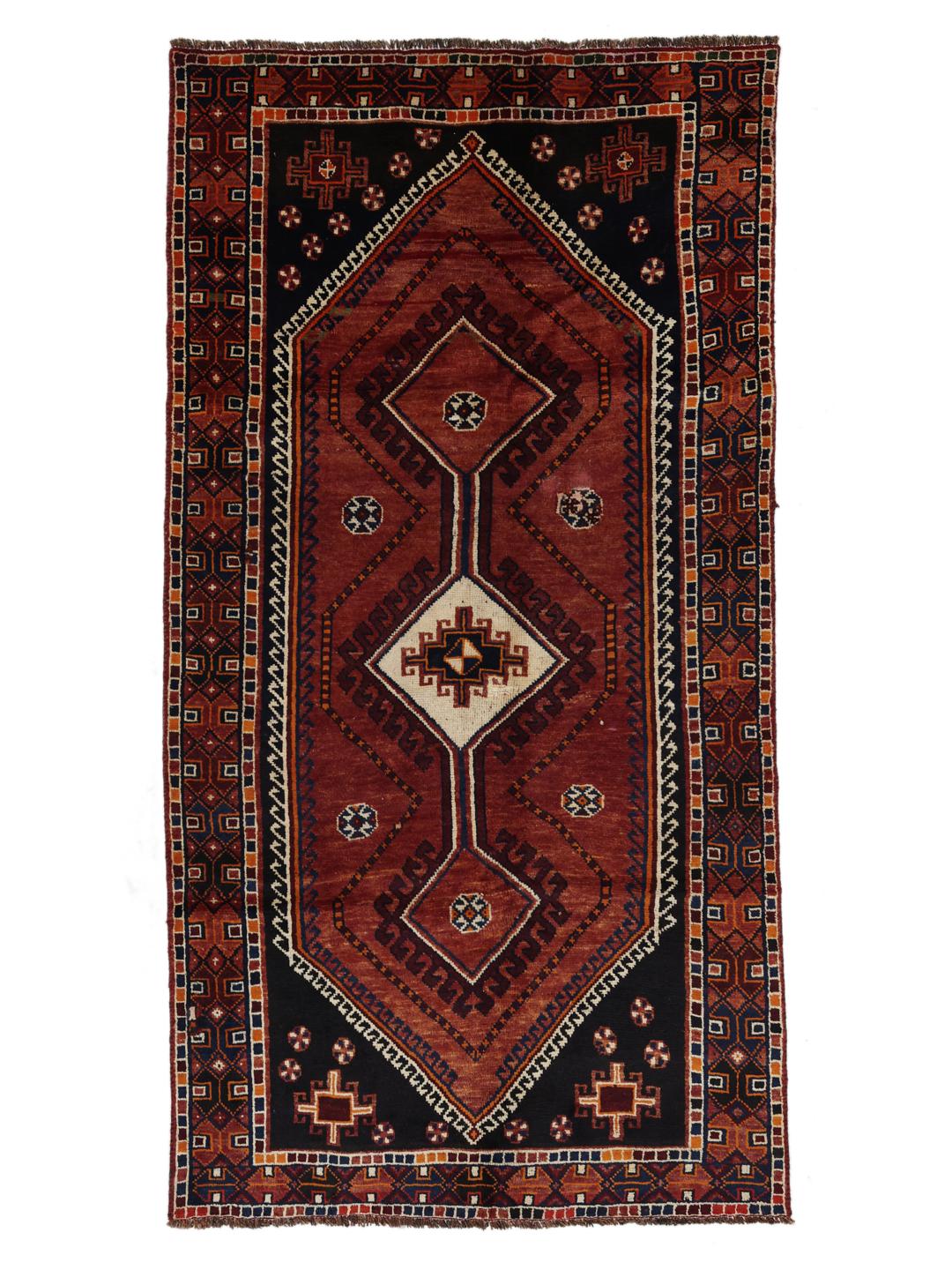 A hand-knotted Shiraz rug from the Middle East featuring a red and black geometric design.