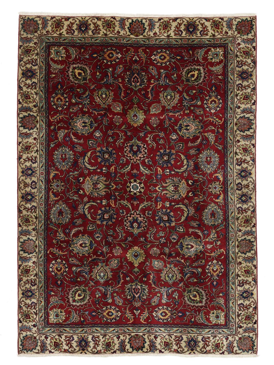 Et håndknyttet Tabriz tæppe fra Mellemøsten med et indviklet blomstermønster på et rødt felt.
