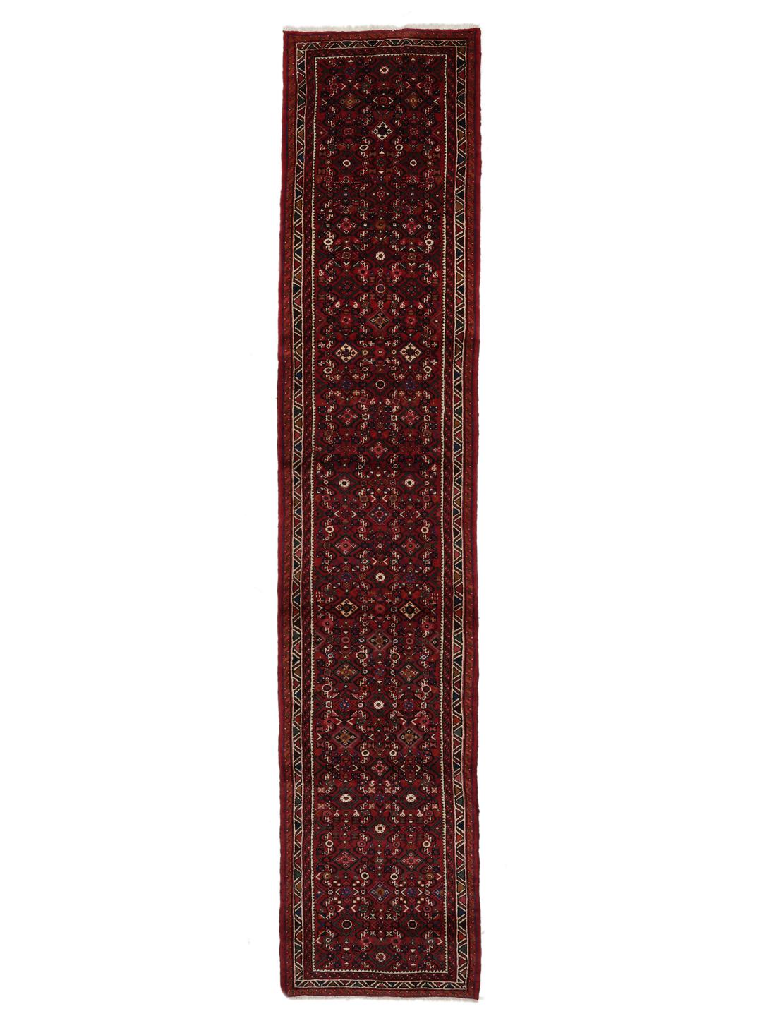 Un long tapis couloir Hosseinabad noué à la main en provenance du Moyen-Orient dans des tons rouge foncé.