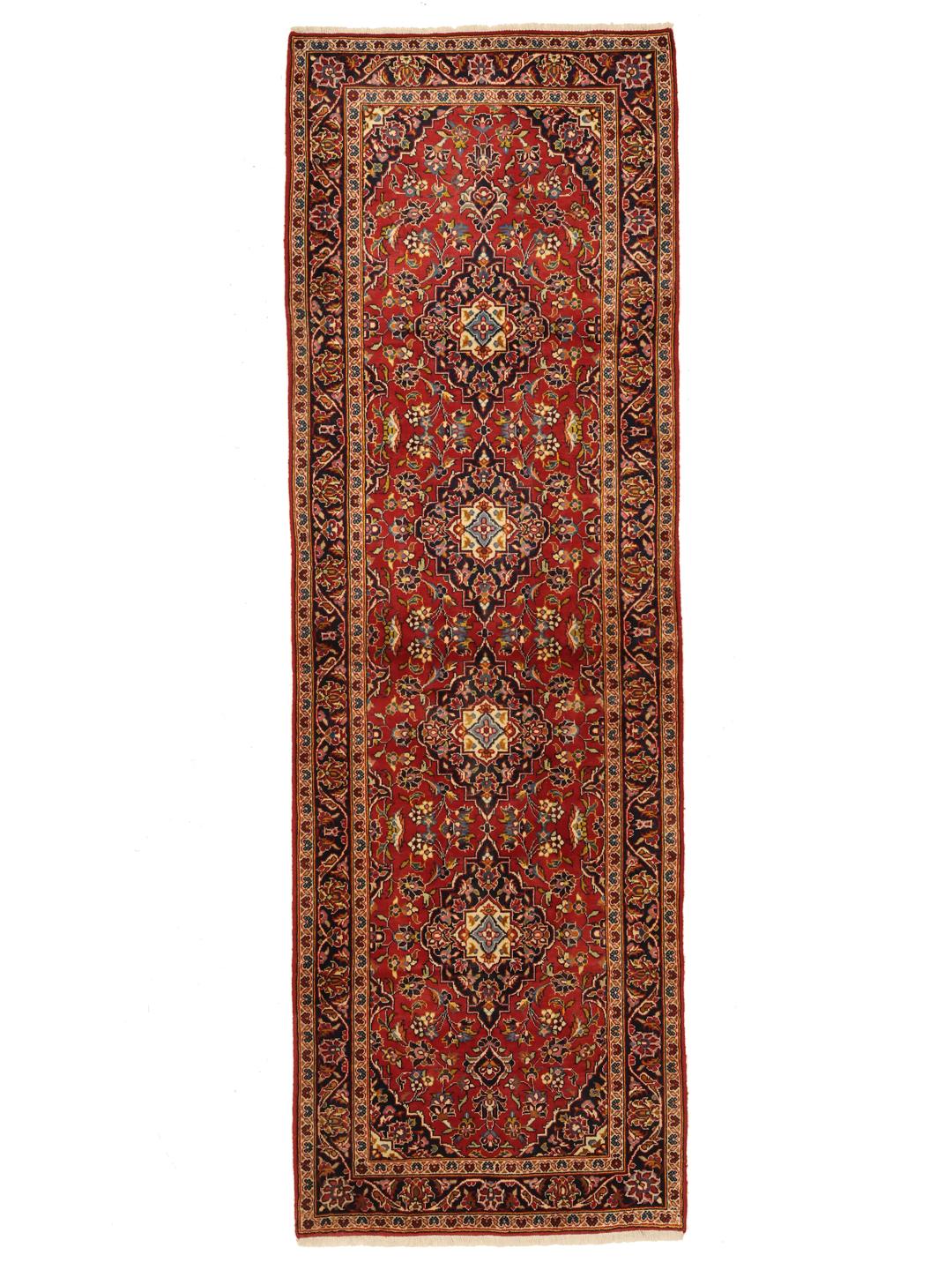 A hand-knotted Middle Eastern Keshan runner in red with floral medallion patterns.