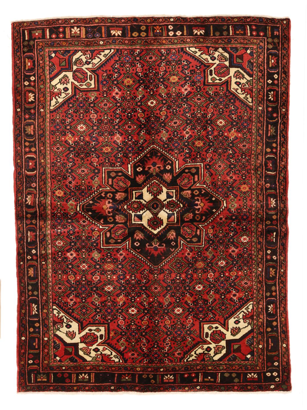 A hand-knotted Hosseinabad rug from the Middle East in deep red and dark blue tones.