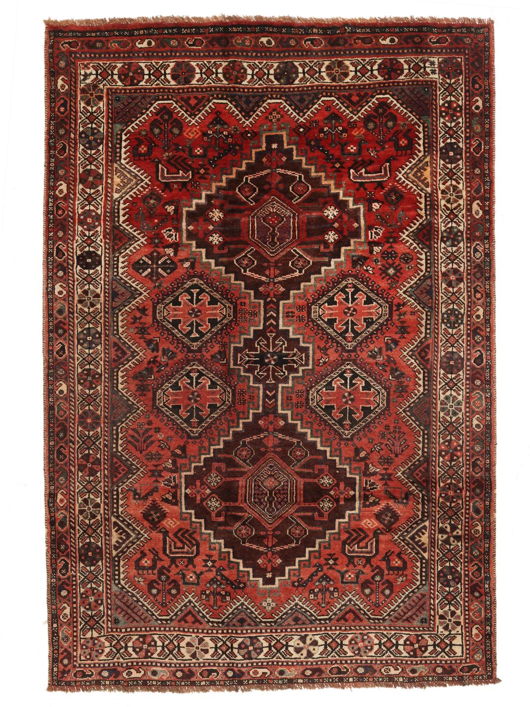 A hand-knotted Shiraz rug from the Middle East featuring geometric red patterns.