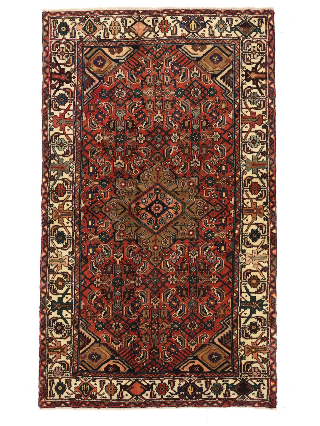 Een handgeknoopt Hosseinabad tapijt uit het Midden-Oosten met een rood veld en traditionele geometrische motieven.