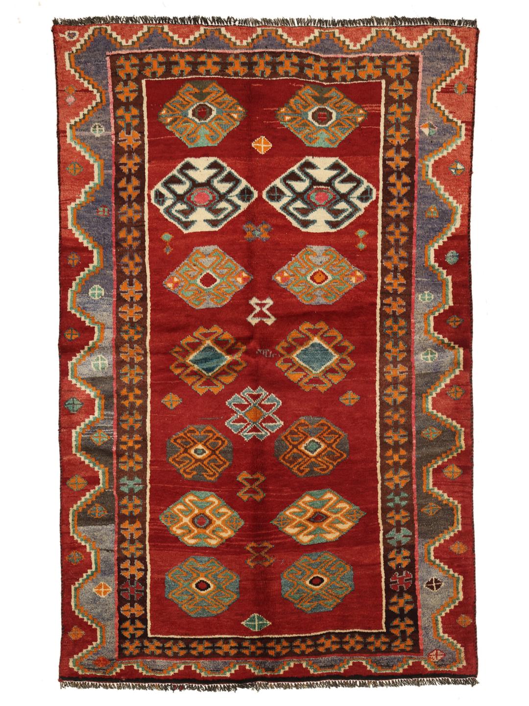 A hand-knotted Ghashghai rug from the Middle East with a vibrant red field and geometric patterns.