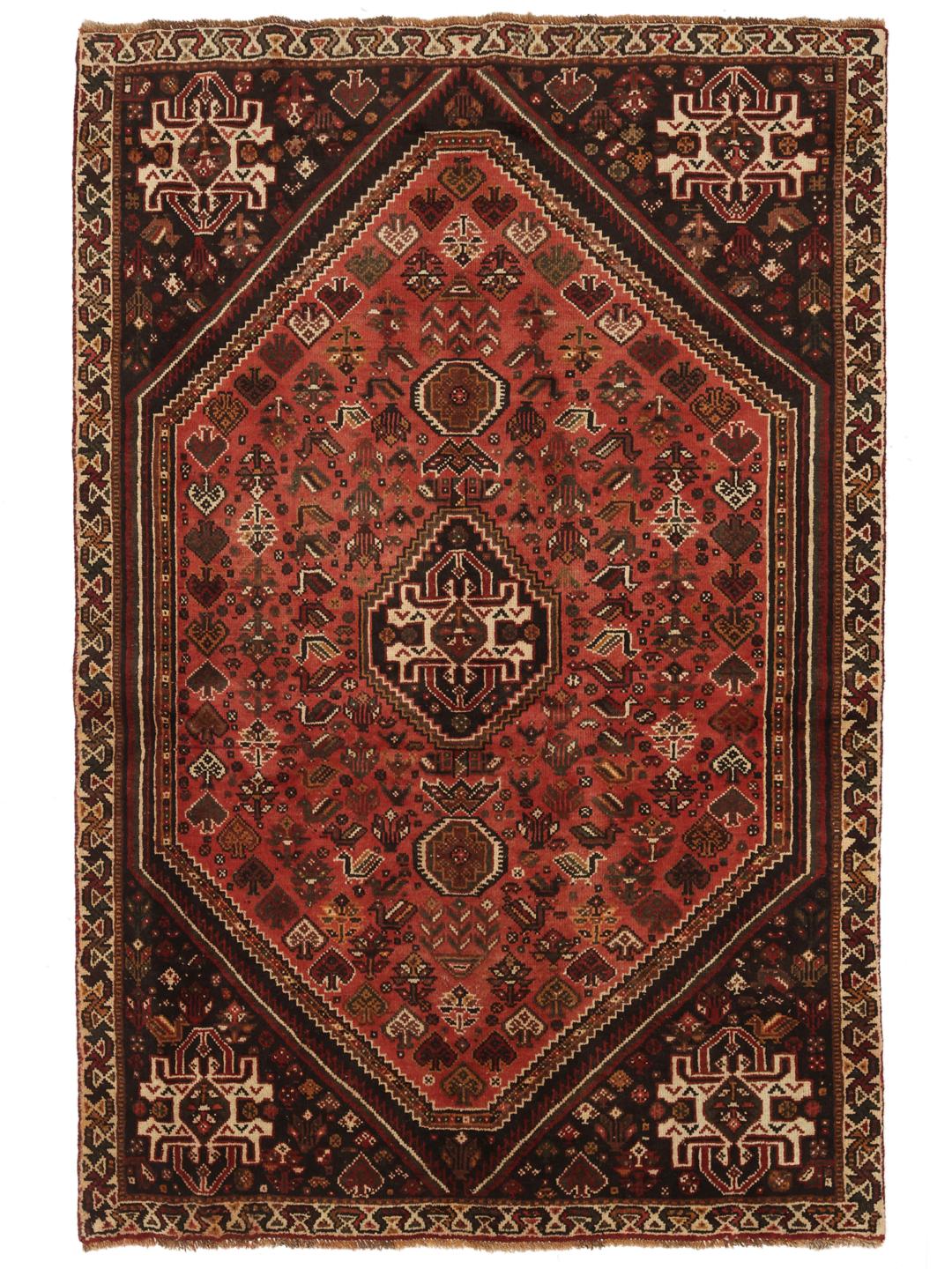A hand-knotted Qashqai rug from the Middle East featuring a red field and decorative borders.