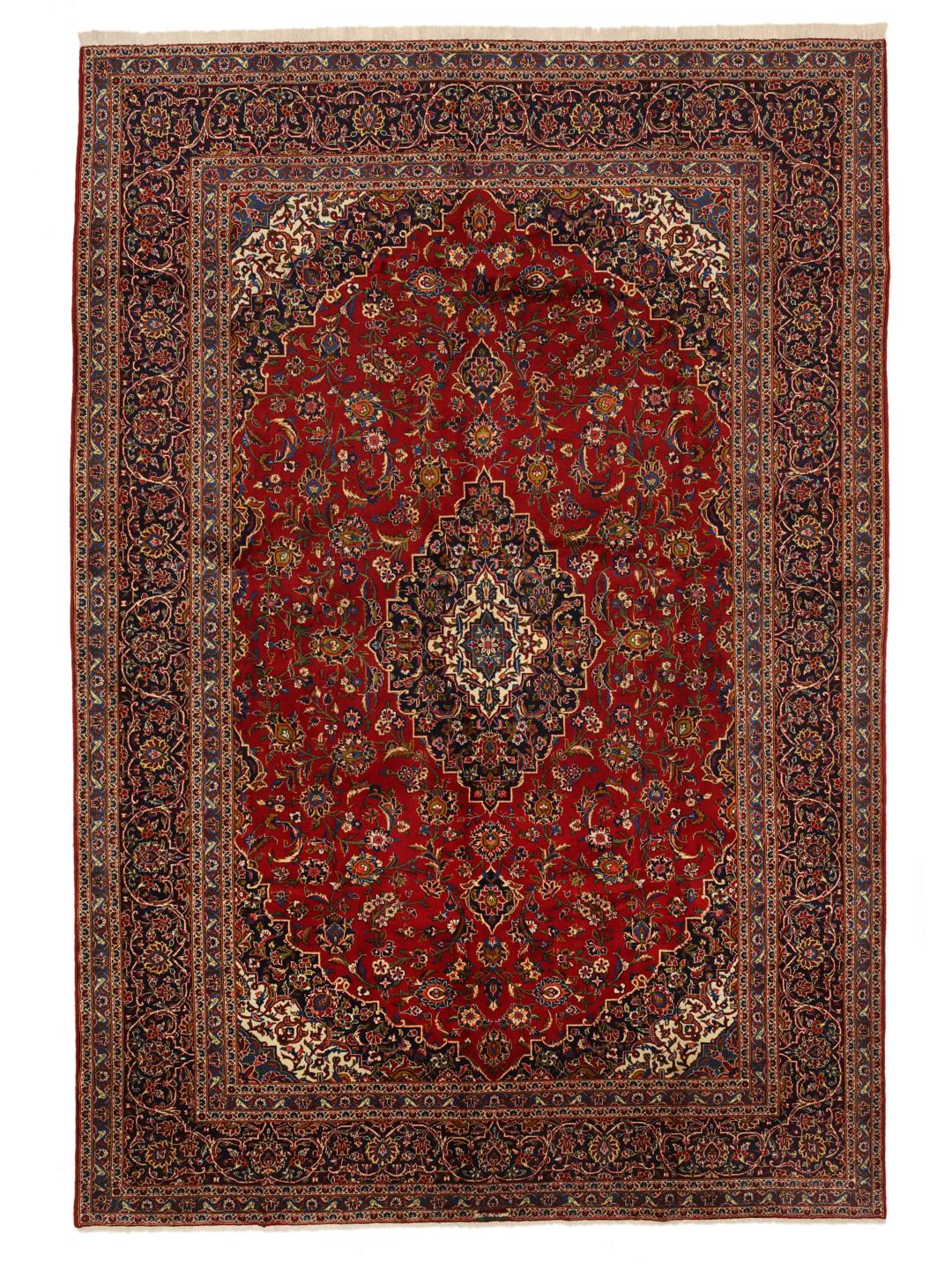 Hand-knotted Keshan rug from the Middle East with a red field and traditional floral medallion.