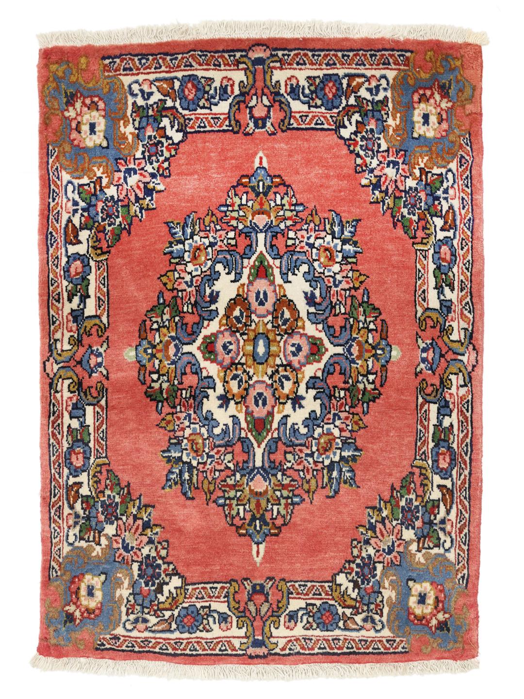 A hand-knotted Sarough rug from the Middle East featuring a vibrant red field and a detailed floral medallion.