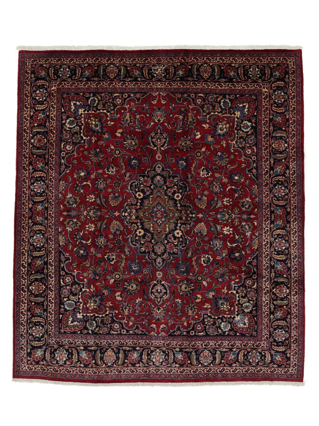 Et håndknyttet Mashad-tæppe fra Mellemøsten med en rød bund og blomstermotiver.