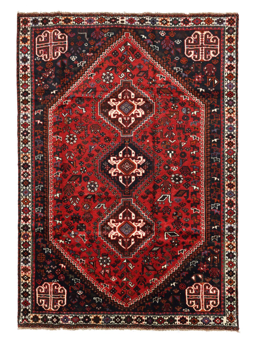 Hand-knotted Qashqai rug with vibrant red and dark tones, originating from the Middle East.