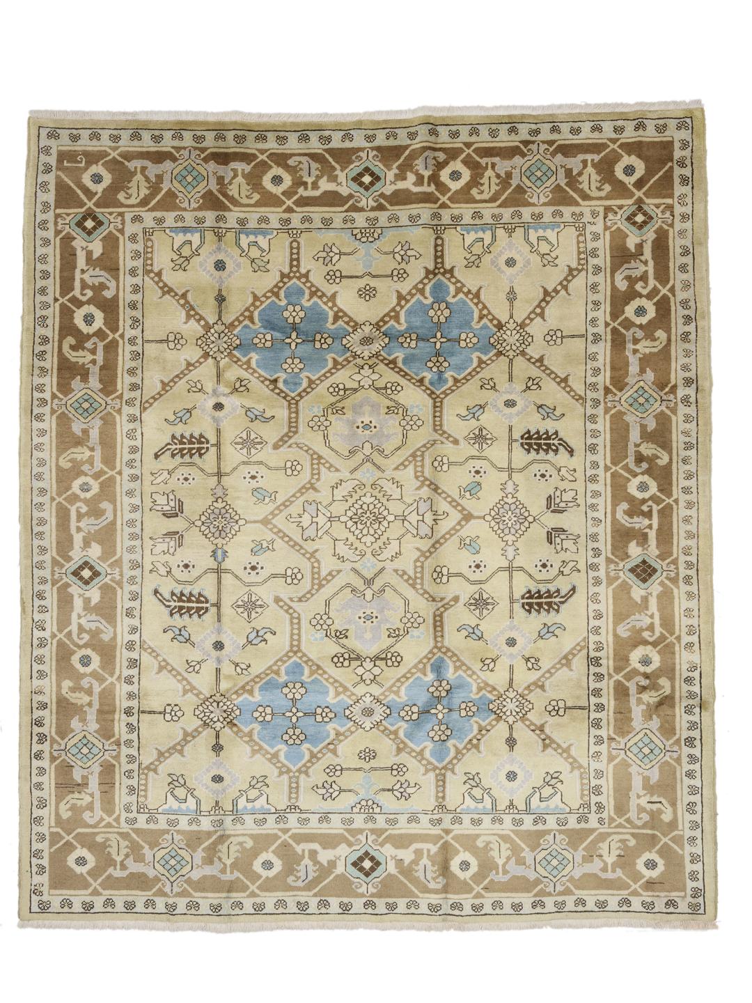 Et håndknyttet Heriz-tæppe fra Mellemøsten med et geometrisk design i beige, blå og brun.
