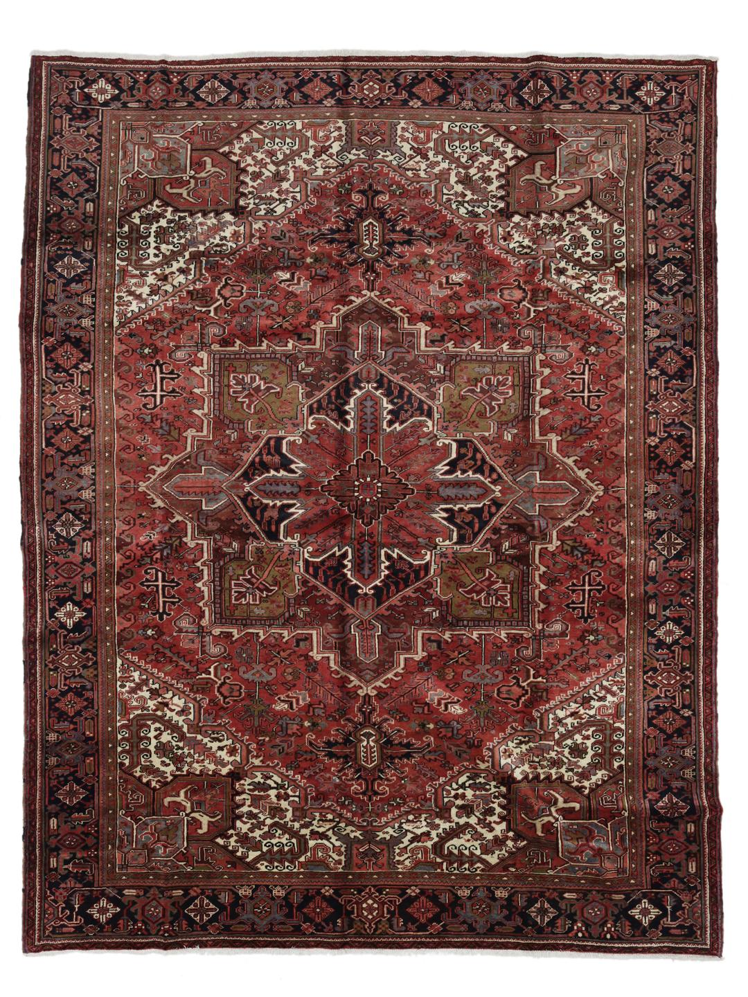 A large, hand-knotted Heriz rug from the Middle East with a red field and geometric medallion.