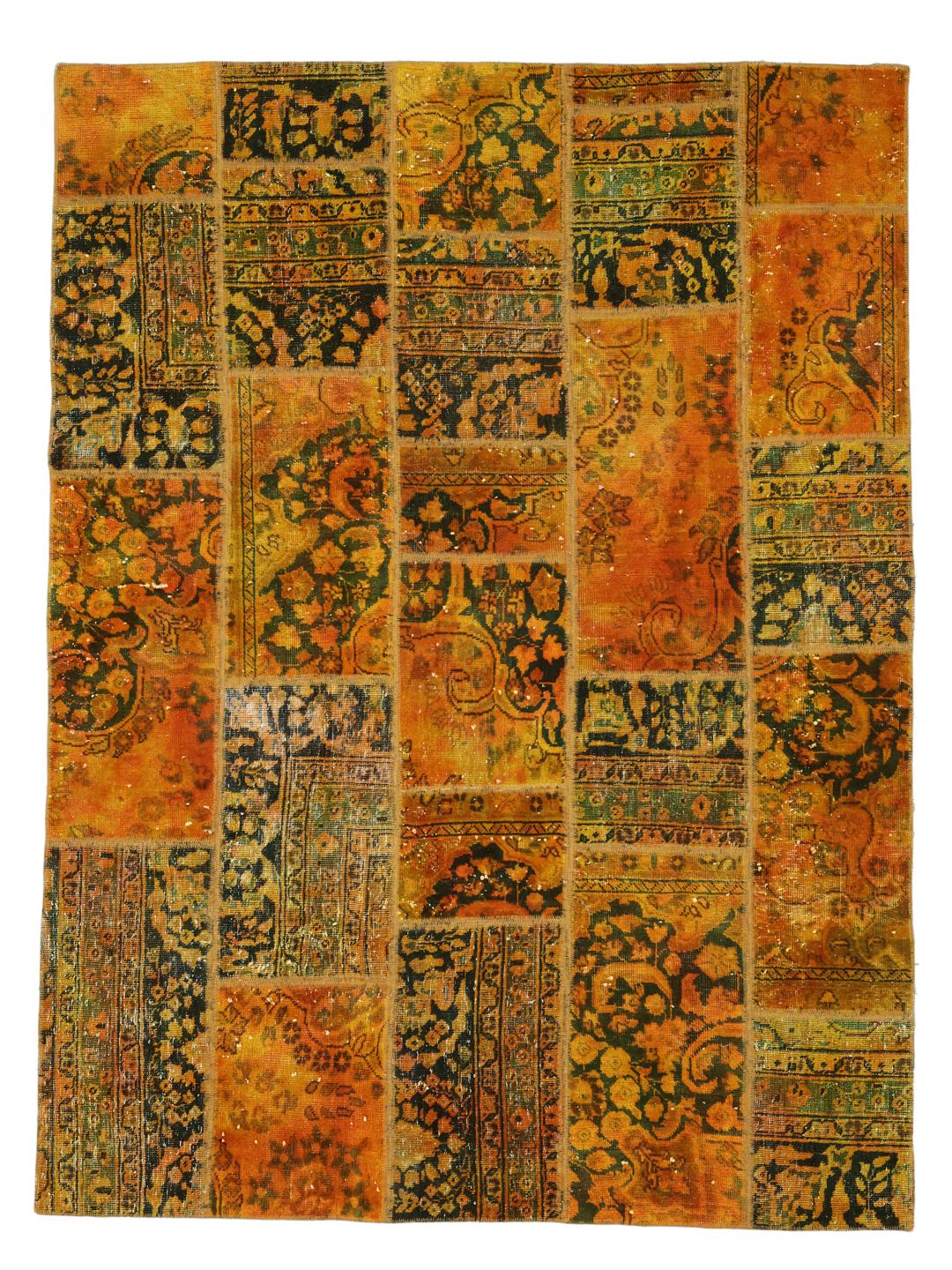 Un tapis patchwork coloré avec des tons orange et vert foncé, présentant des motifs vintage complexes.