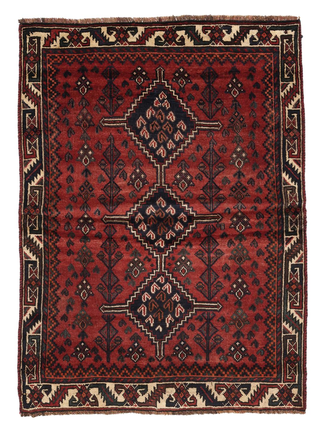 A hand-knotted Shiraz rug from the Middle East featuring geometric patterns in dark red and deep blue