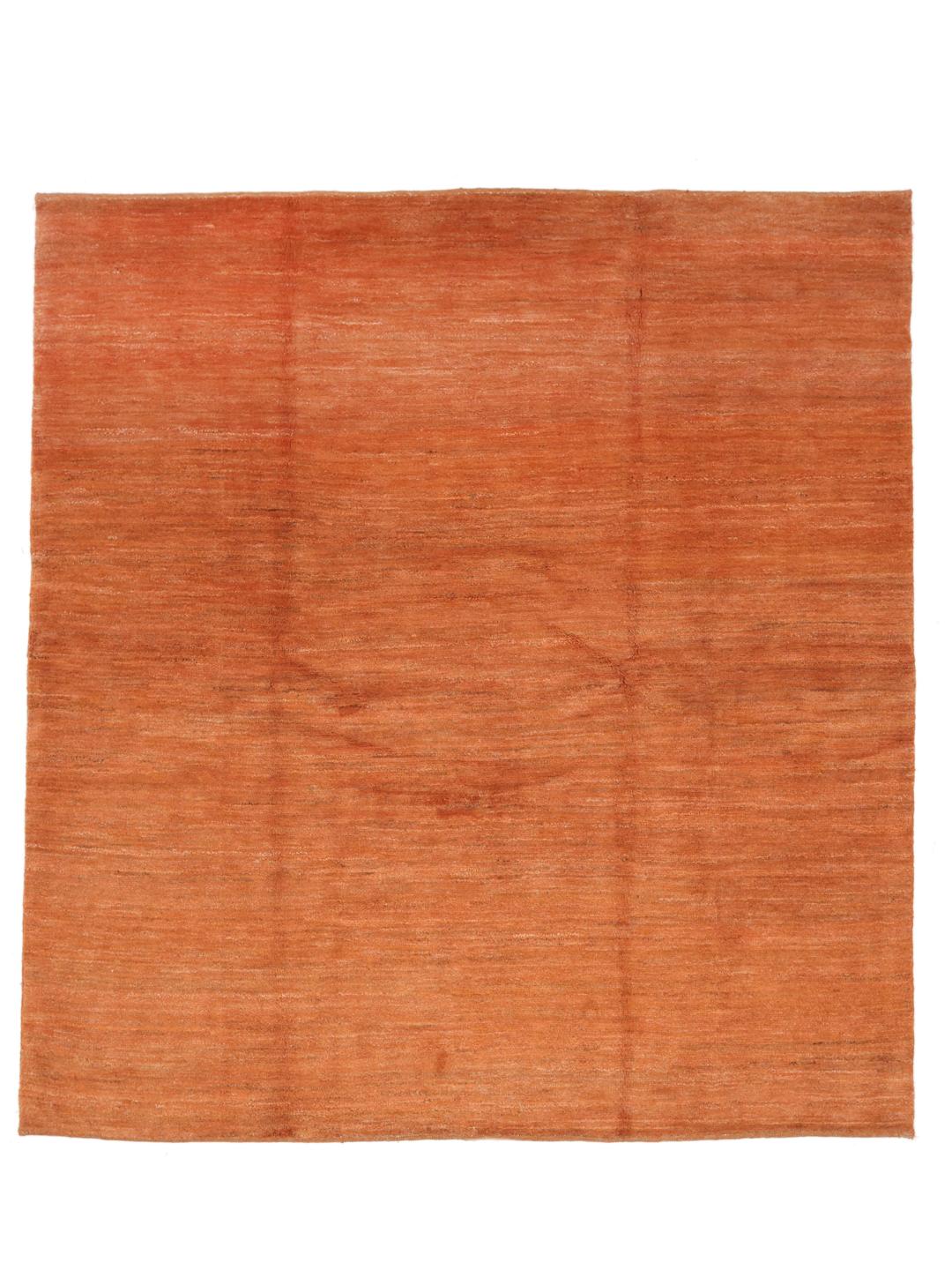 Een vierkant, oranje, handgeknoopt Gabbeh-kleed uit het Midden-Oosten.