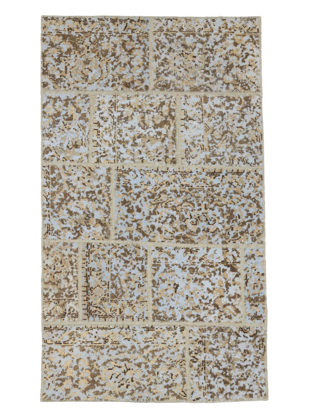 Et rektangulært patchwork-tæppe fra Mellemøsten med en blanding af beige og lyseblå toner.