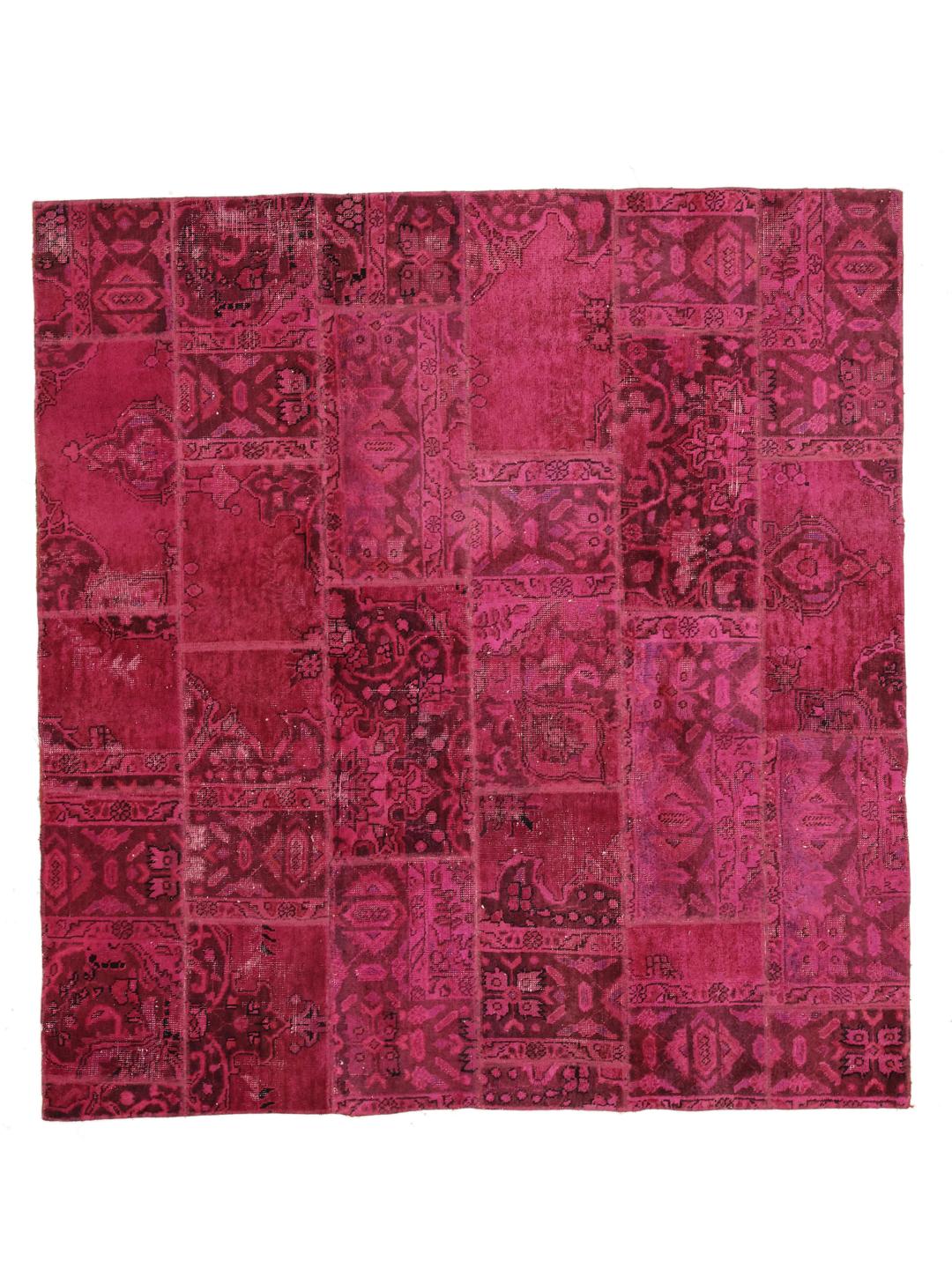Een levendig vierkant patchwork tapijt met dieproze en rode tinten, handgeknoopt in het Midden-Oosten.