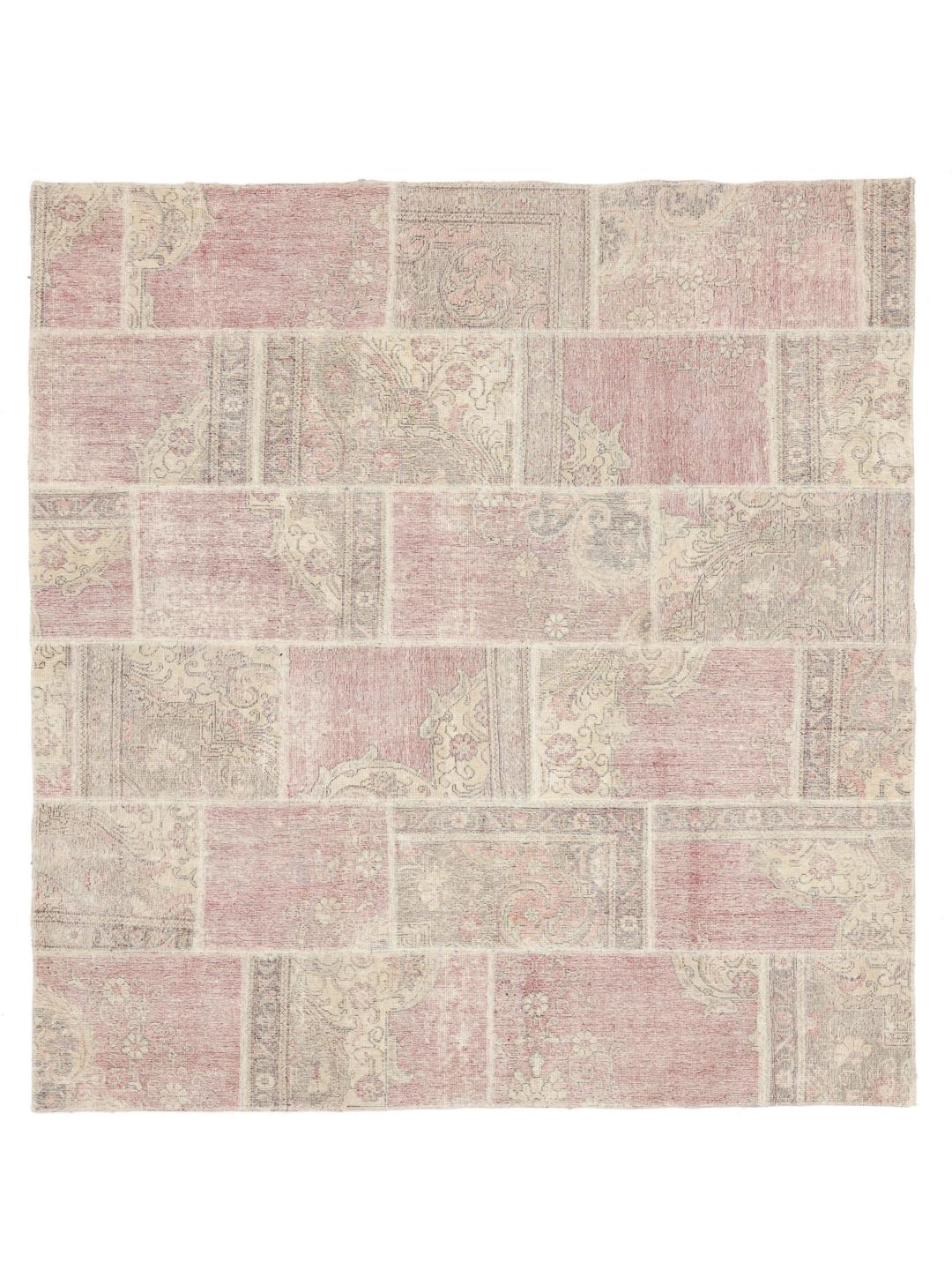 Et kvadratisk patchwork-tæppe med lyserøde og beige blomstermotiver og en patineret finish.