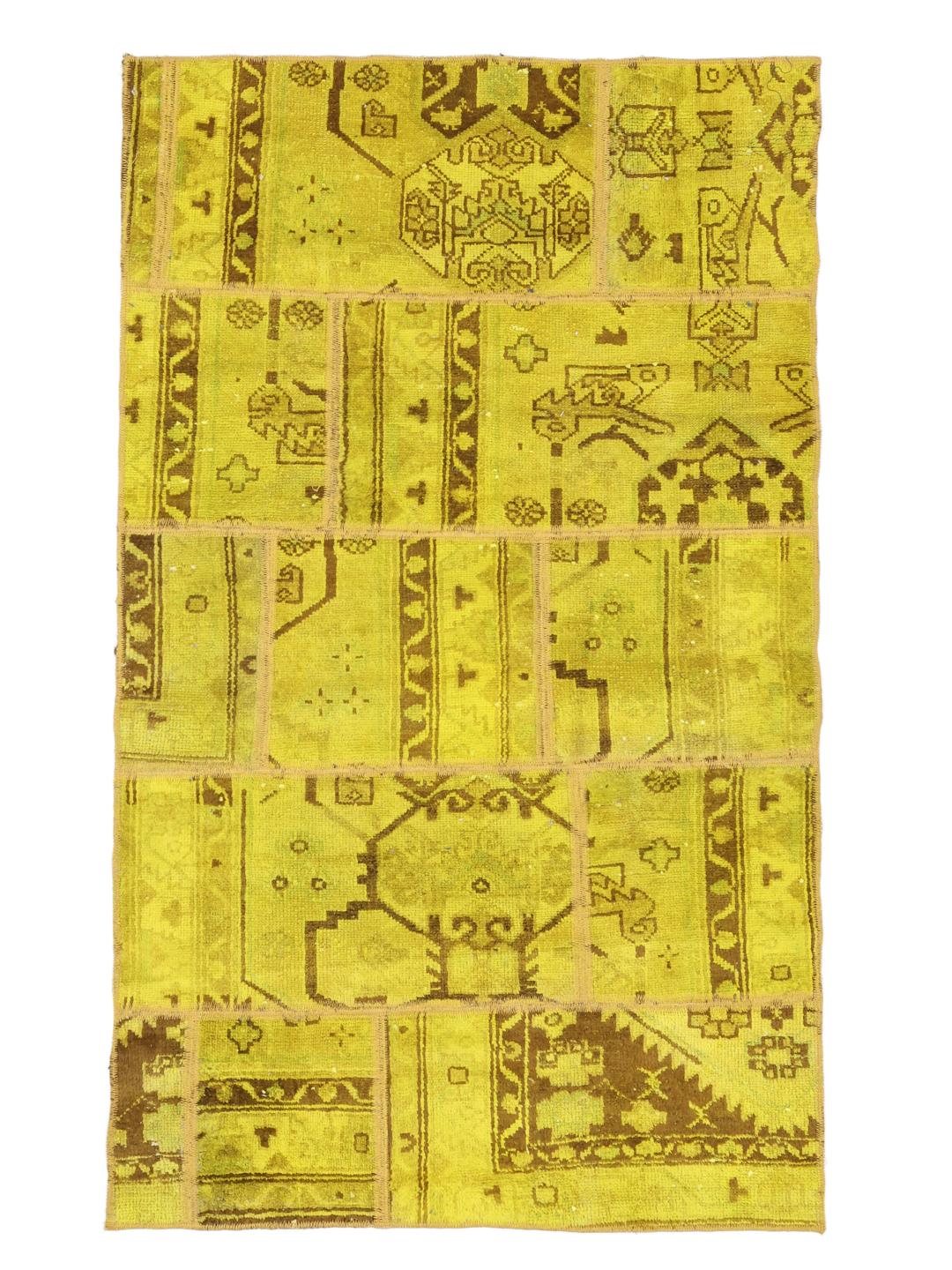 Et levende gult patchwork-tæppe med indviklede mønstre fra Mellemøsten og et unikt håndsyet design.