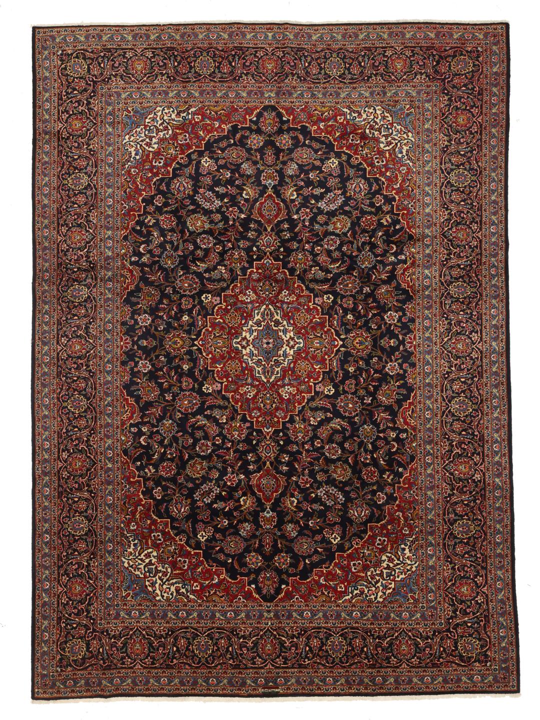 A large rectangular hand-knotted Keshan rug from the Middle East with a dark-blue and dark-red floral pattern.