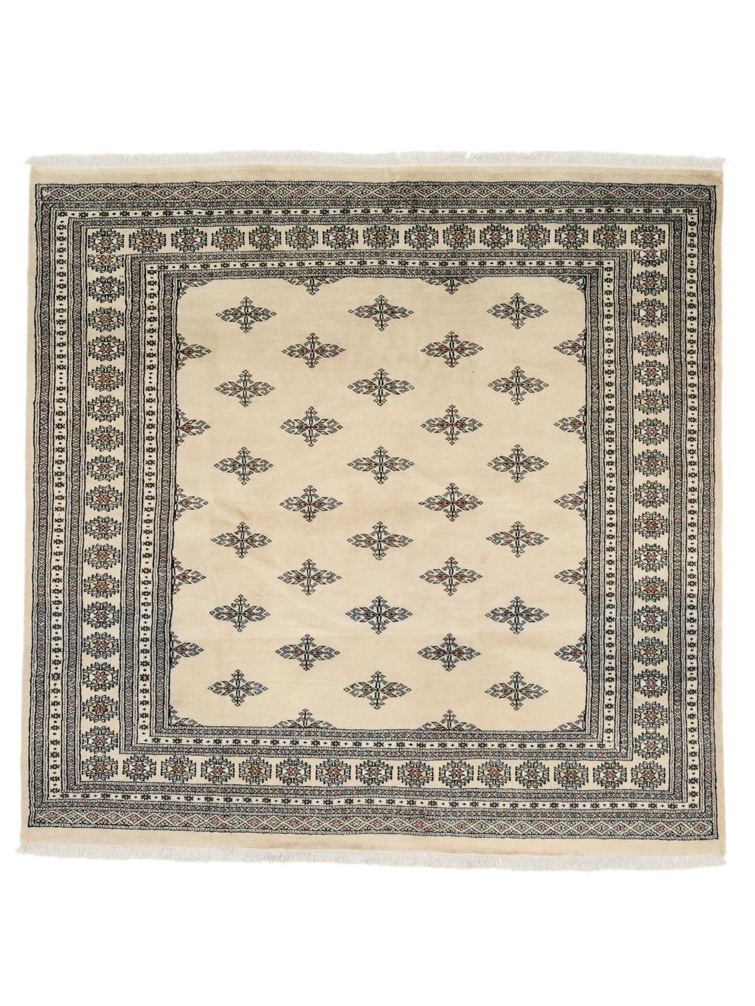 Un tapis Bokhara carré originaire du Pakistan avec un champ beige clair et des motifs floraux répétitifs.