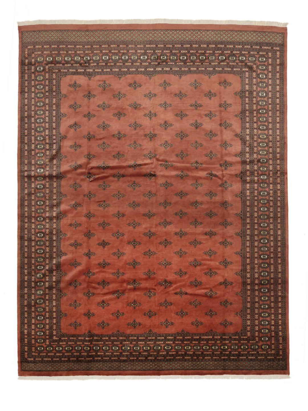 A hand-knotted Pakistani Bokhara rug with a warm red field and geometric motifs