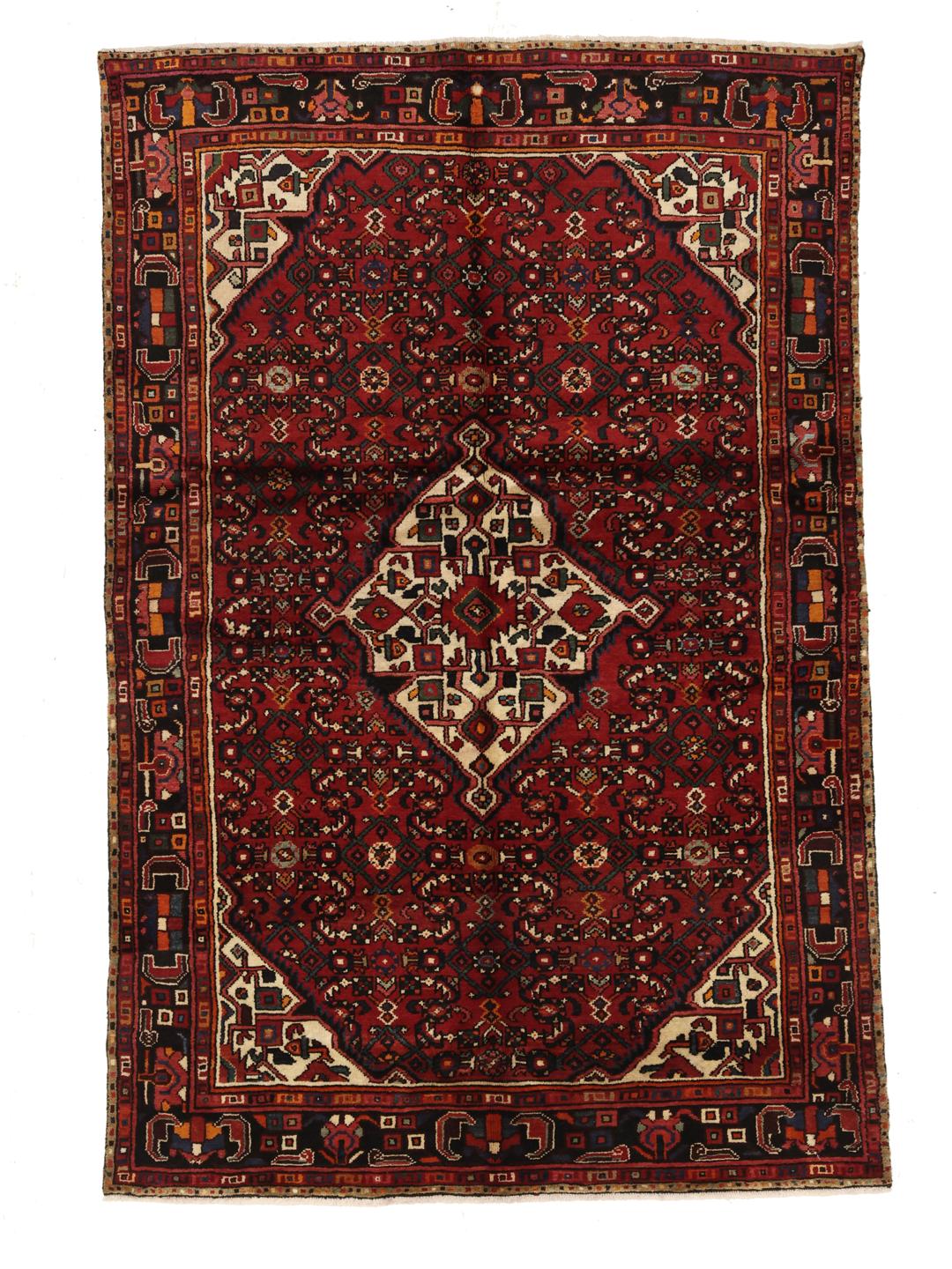 Hand-knotted Hosseinabad rug with geometric patterns in red and dark blue.