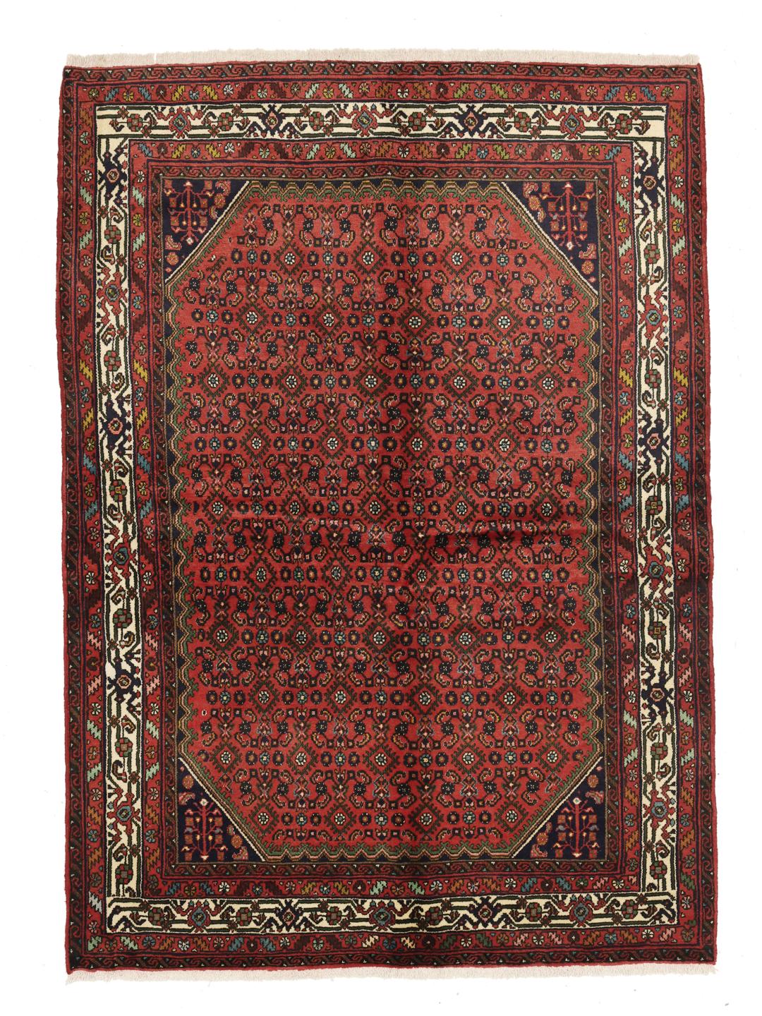A hand-knotted red Hosseinabad rug from the Middle East.