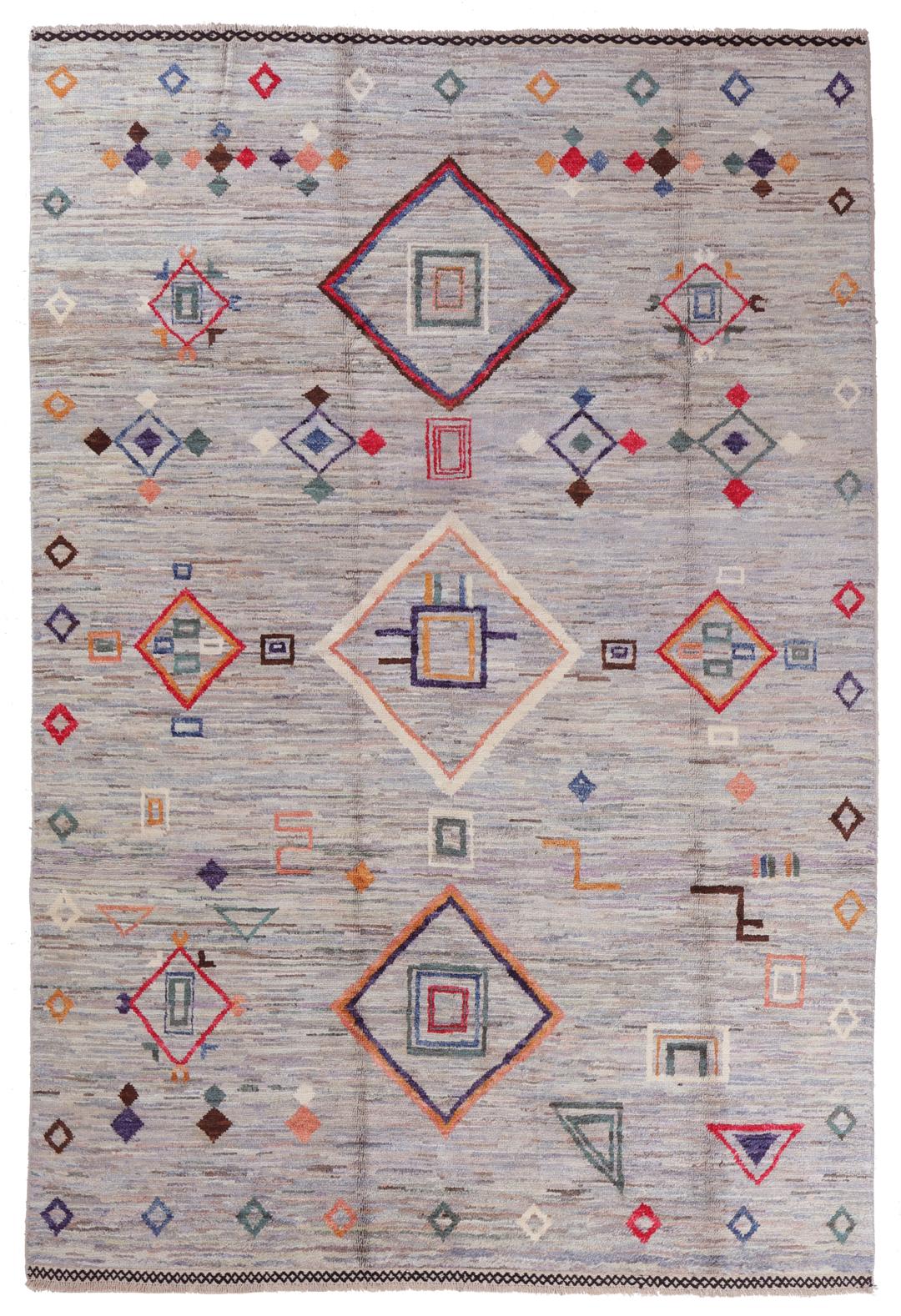 A large hand-knotted Afghan Berber rug with geometric motifs on a blue field.