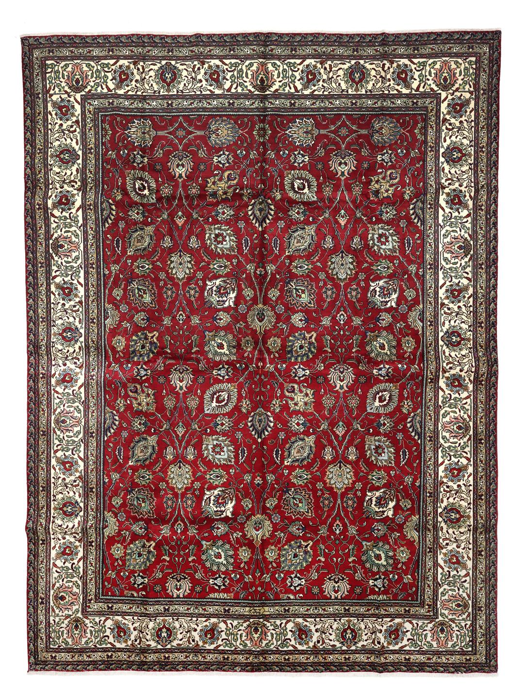 Een groot, handgeknoopt Tabriz-tapijt met een dieprood veld en ingewikkelde bloempatronen.