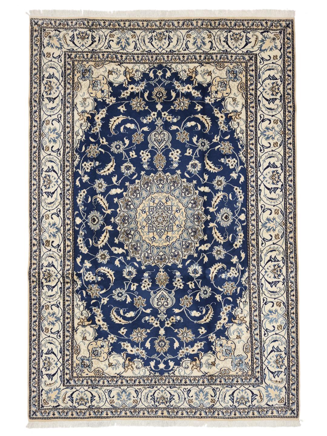 A hand-knotted Nain rug from the Middle East with a deep blue and cream floral pattern.