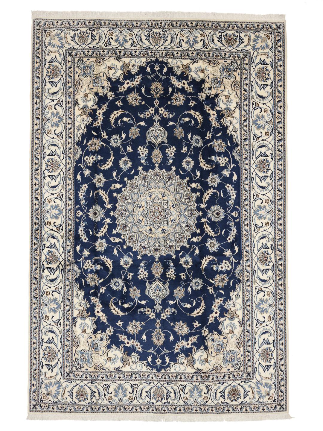 A hand-knotted Nain rug from the Middle East featuring a blue field with floral patterns.