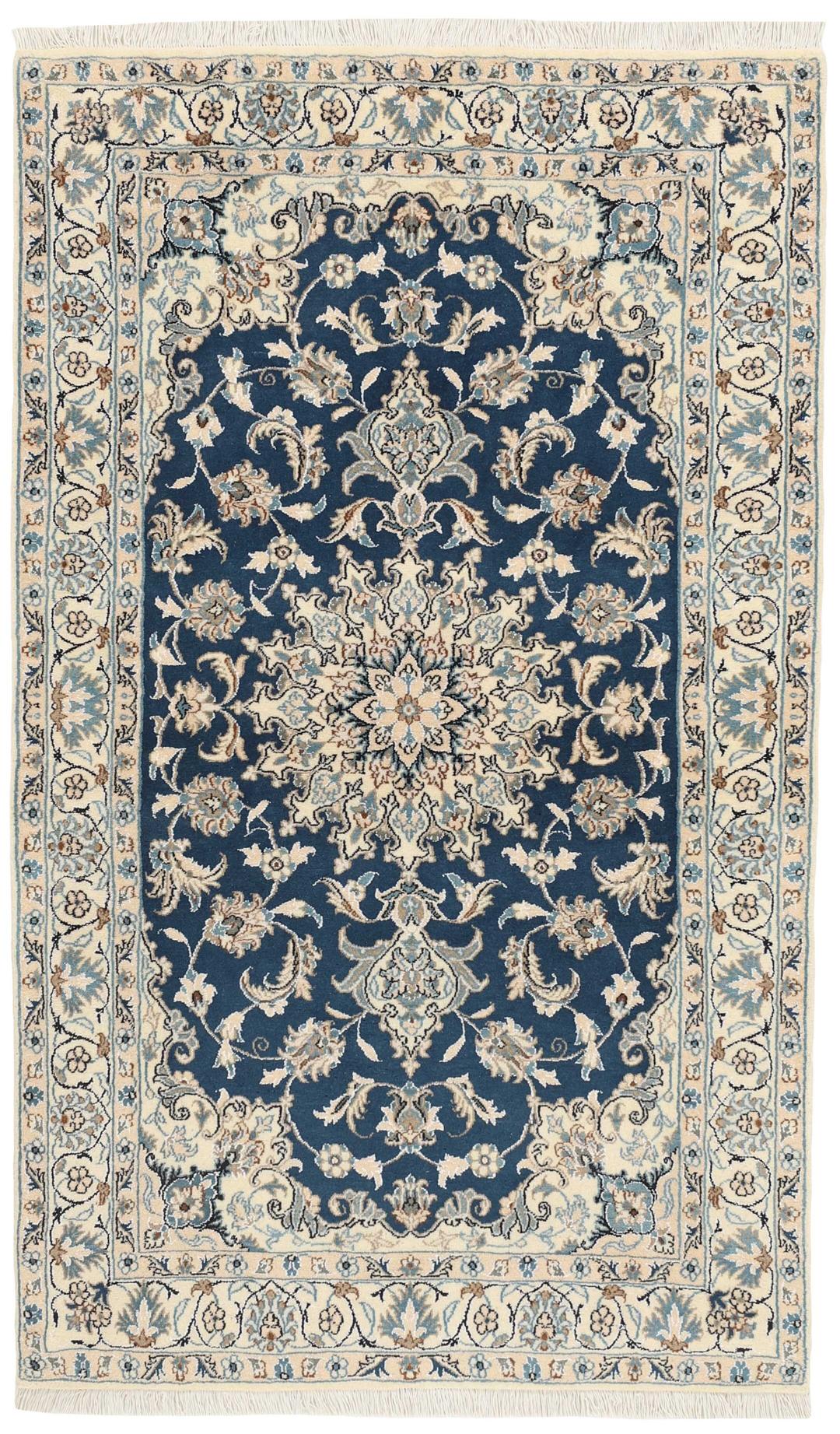 A rectangular handmade Nain rug from the Middle East featuring a blue field with floral patterns.