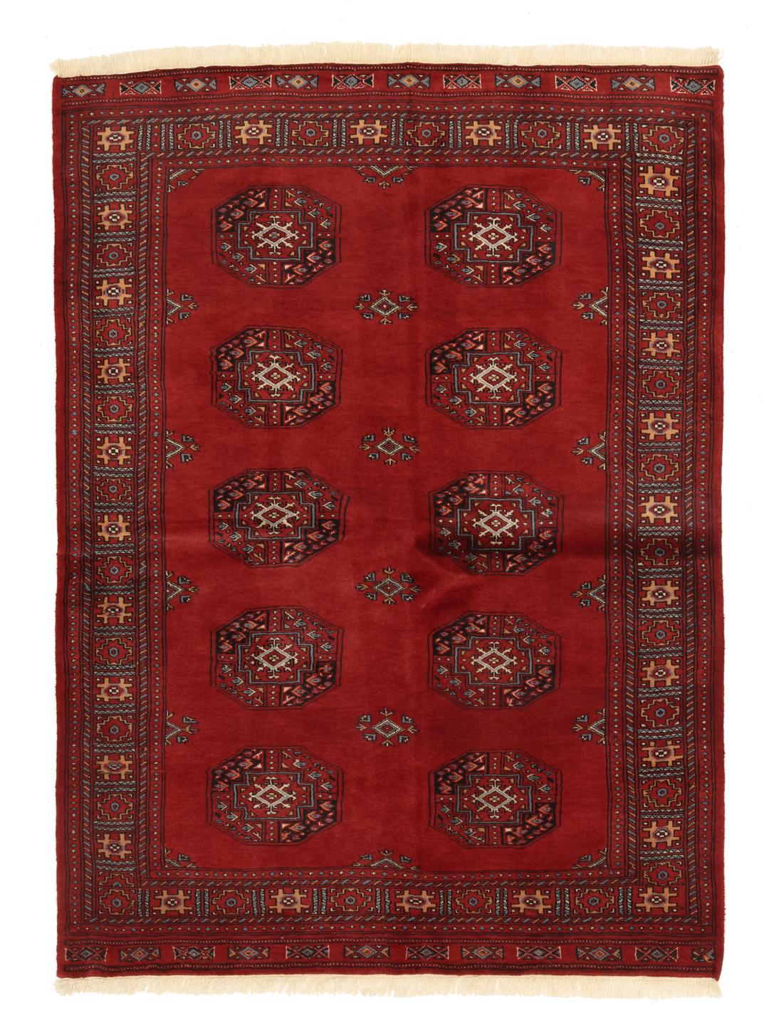 Red rug from Pakistan with traditional geometric motifs.
